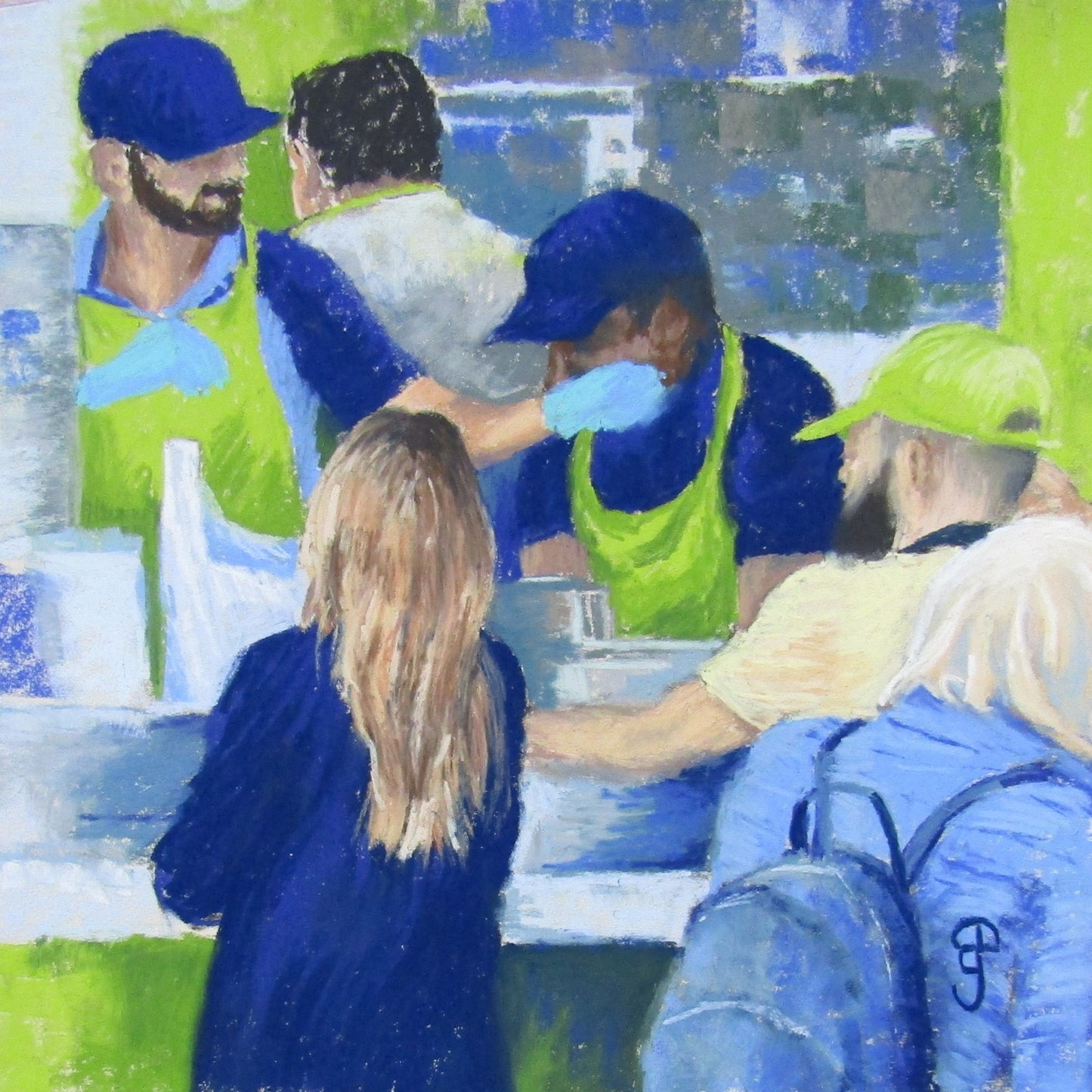Busy Street food traders in blue and green uniforms at Birmingham Market serving falafel and fresh juice to customers